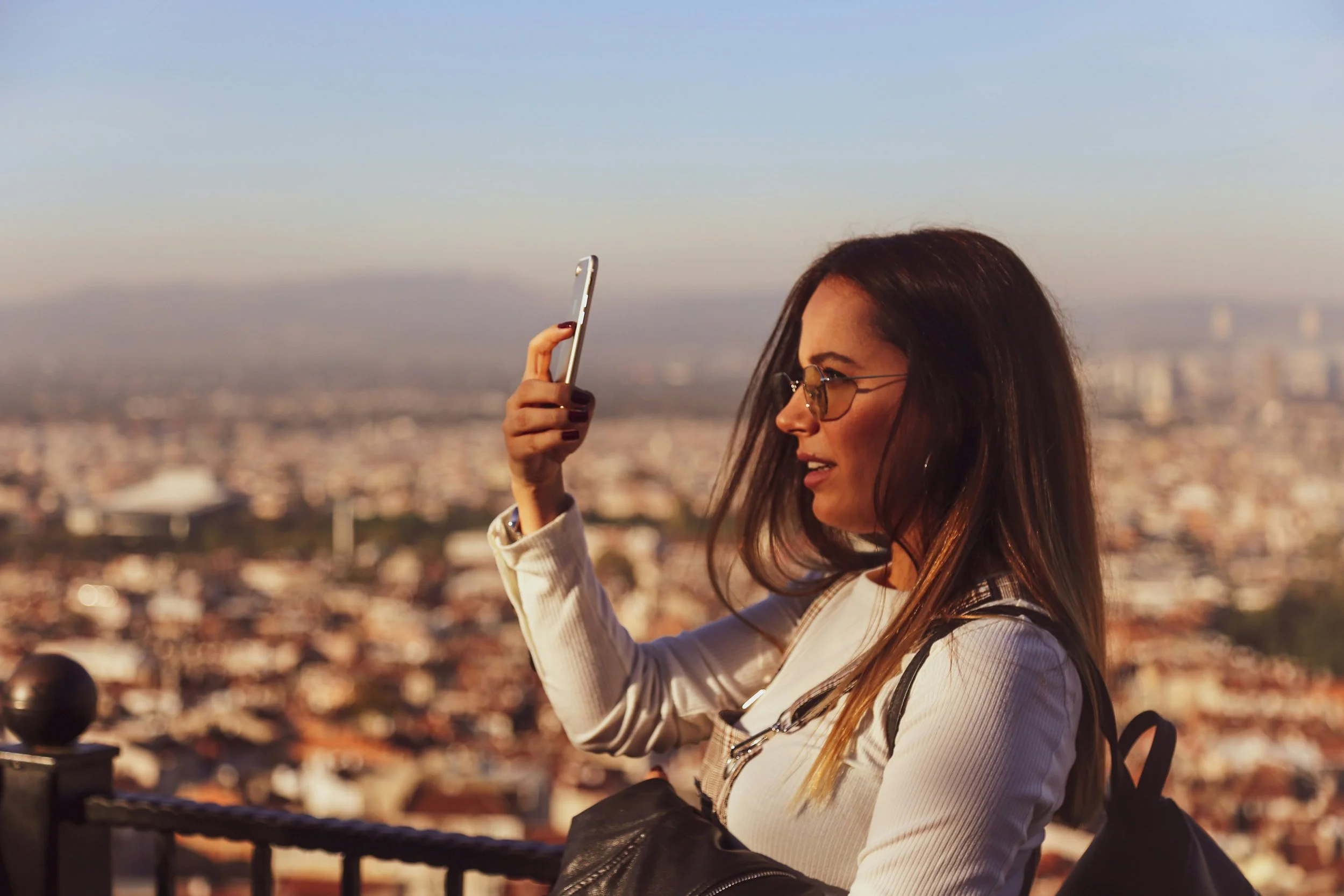 woman-traveler-taking-picture-with-England-city-scene-in-background