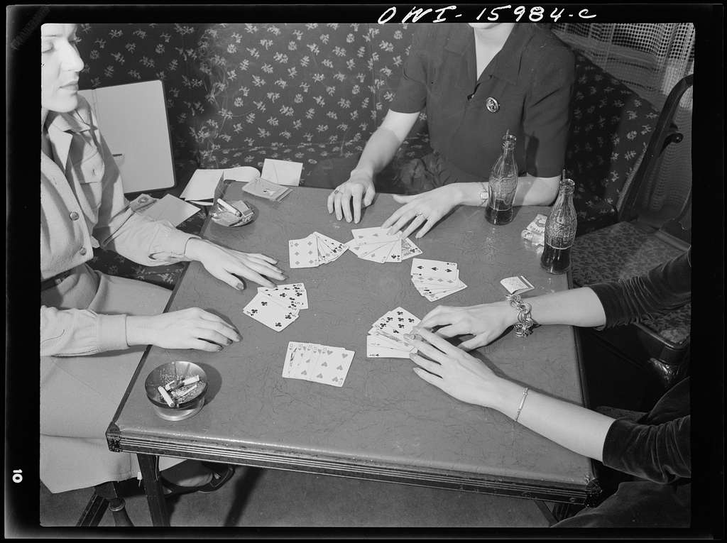 group-of-woman-sitting-around-table-playing-cards