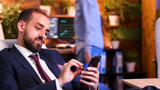 business-man-in-suit-checking-phone-at-nice-place